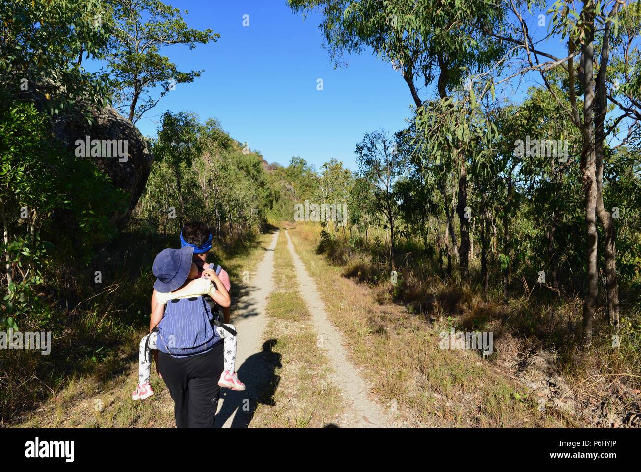 Mutter trägt schlafenden Kind auf dem Rücken in einem Kind Träger, viele Gipfel Wanderung zum Berg Marlow, Townsville Stadt gemeinsame Queensland, 4810, Australien Stockfoto