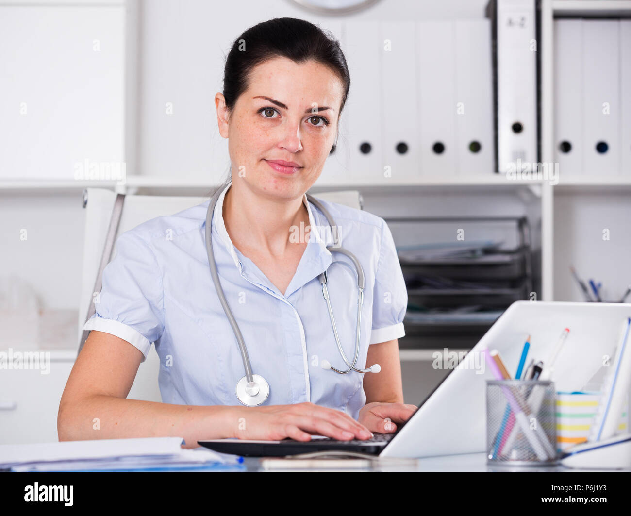 Porträt der jungen medizinischen Arbeiter in Medical Center in der Nähe des Tisches Stockfoto
