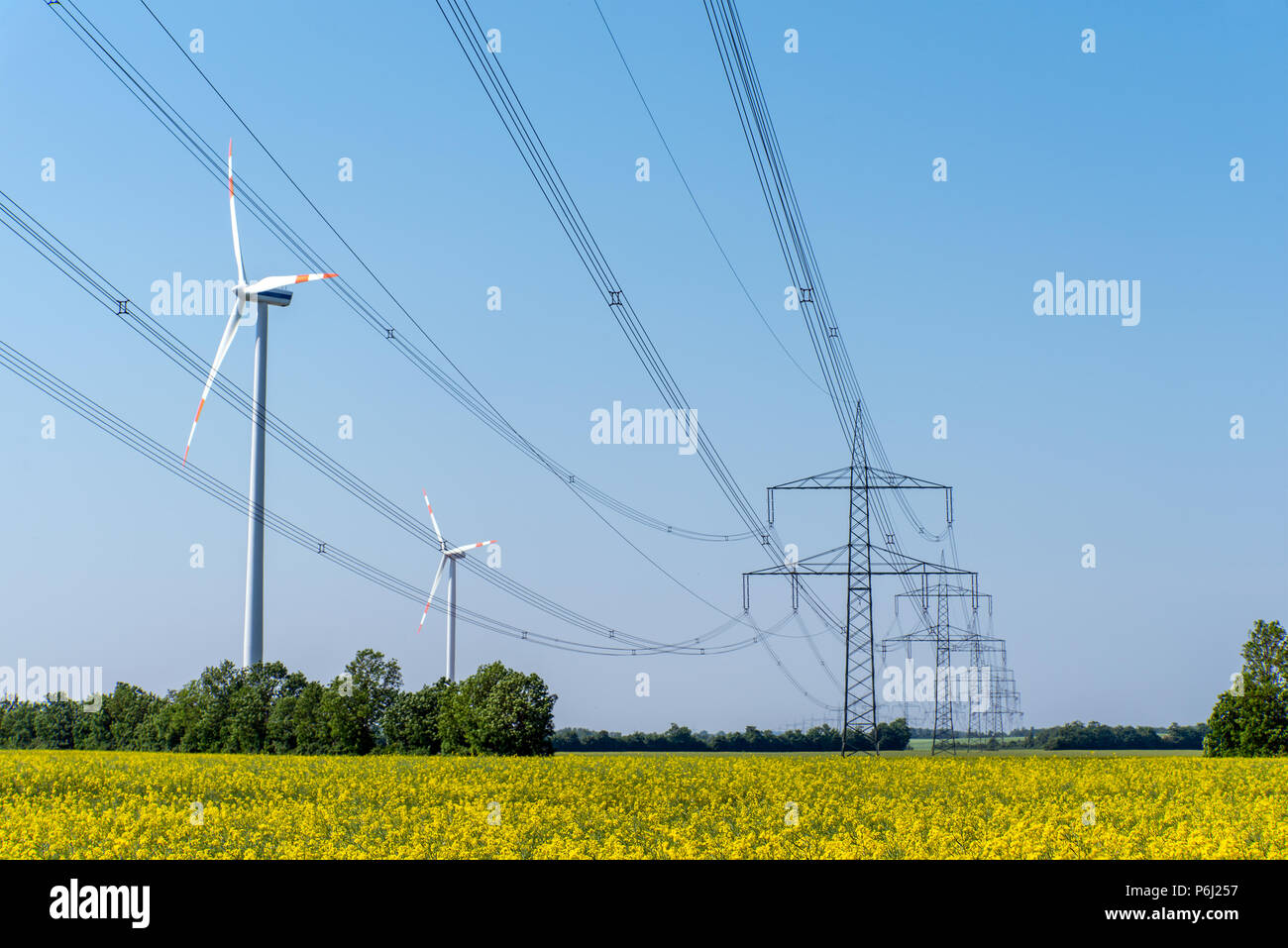 Versorgungsleitungen und einige Windkraftanlagen in ländlichen Deutschland gesehen Stockfoto