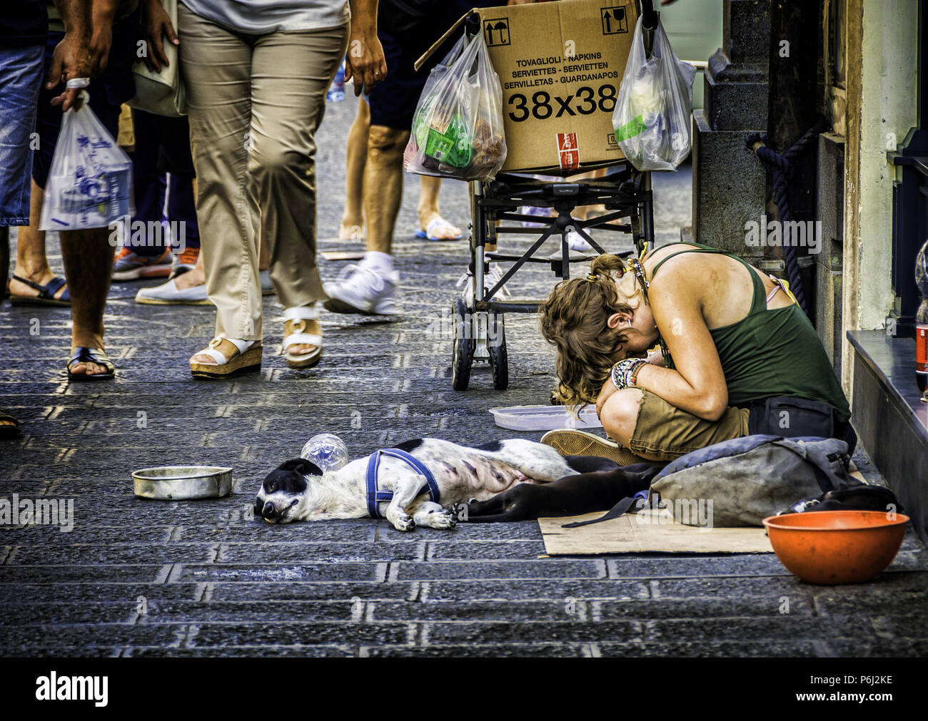 23. August 2014 - Sizilien, Italien. Arme junge Obdachlose Frau mit dem Hund, sitzen und um Geld betteln in den geschäftigen Straßen der Küstenstadt Catania Stockfoto