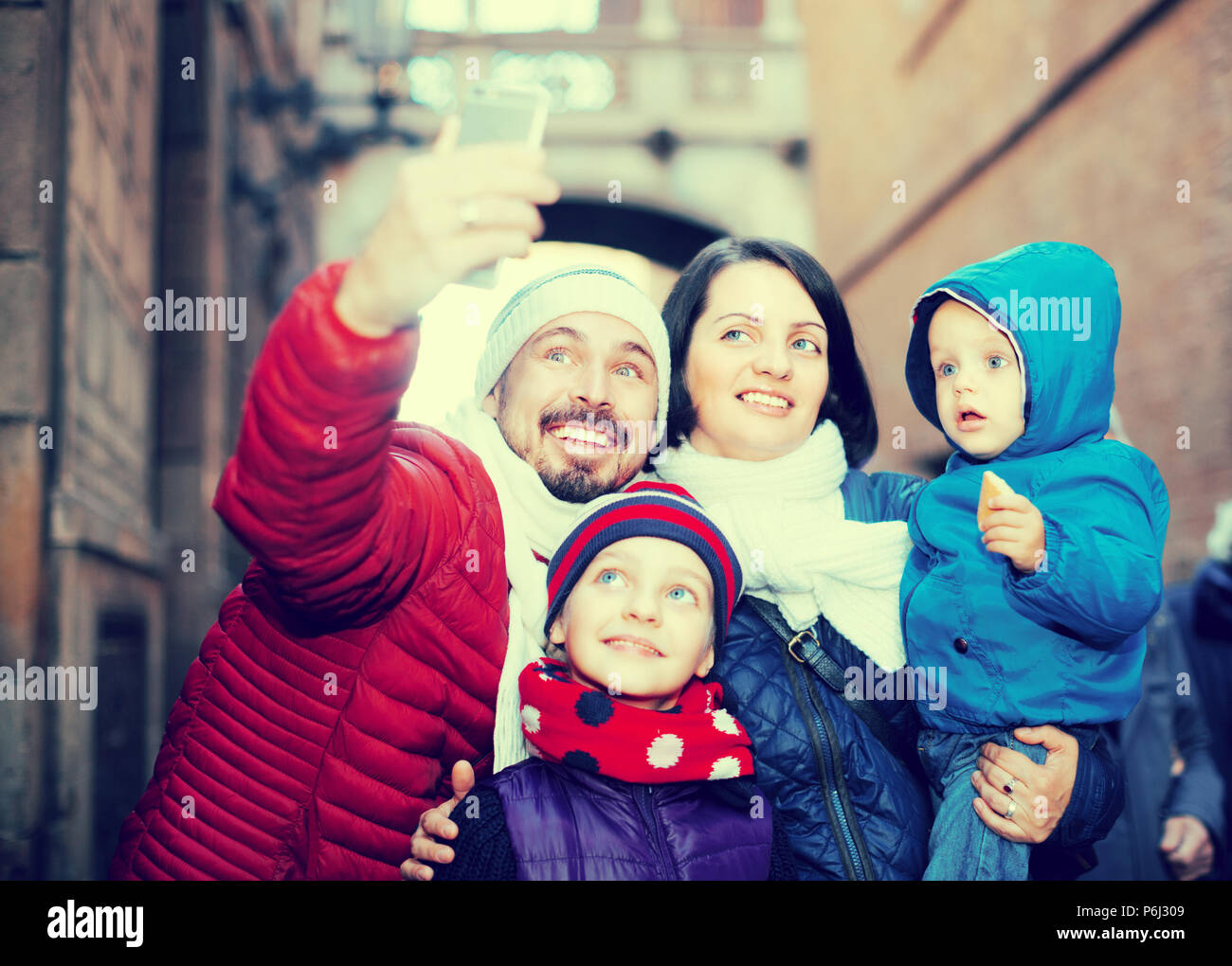 Mama und Papa mit ihren kleinen Kindern tun selfie im Freien. Stockfoto