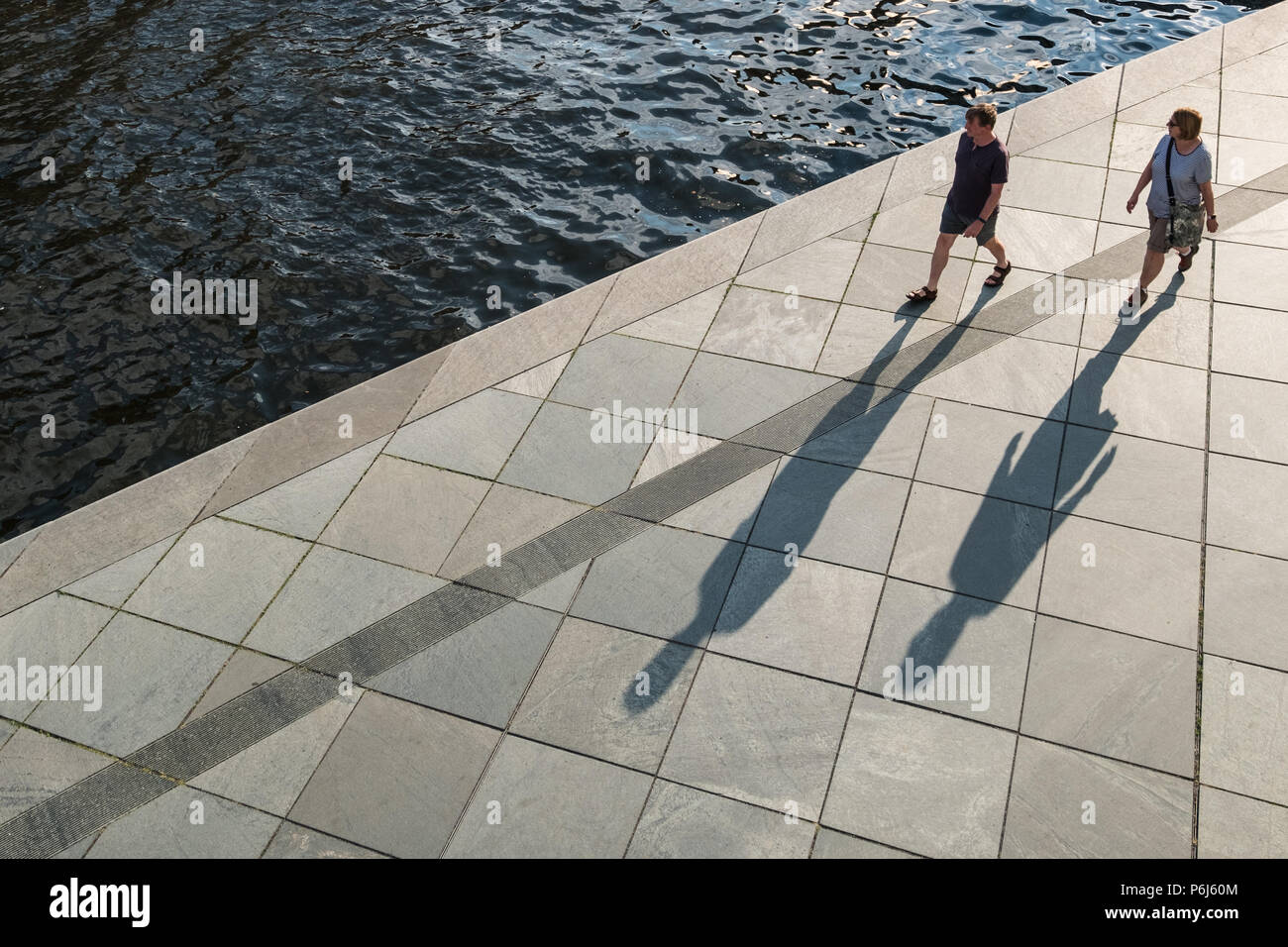 Zwei Leute auf dem Bürgersteig mit langen Schatten von oben Stockfoto