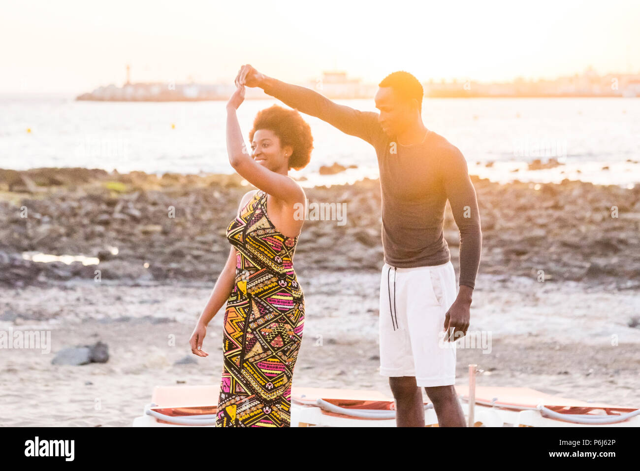 Gerne schön schön schwarz african Race Paar genießen und Tanz am Meer während einer goldfarbenen outdoor Sonnenuntergang. Glück und Freundschaft relationsh Stockfoto