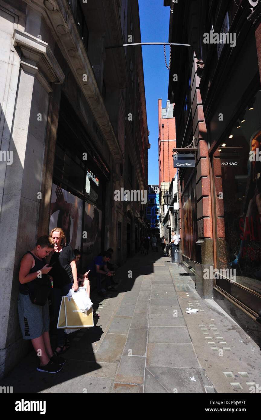 Mutter und Kind Schutz vor der Sonne in der Gasse zwischen Regent Street und Canarby Street, London, England, Großbritannien Stockfoto