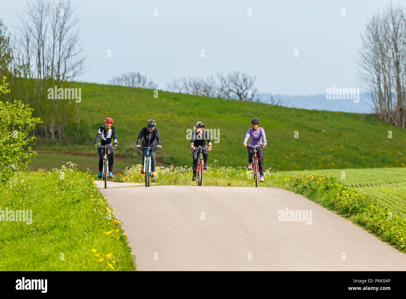 Vier Frauen Fahrräder auf einer Landstraße Stockfoto