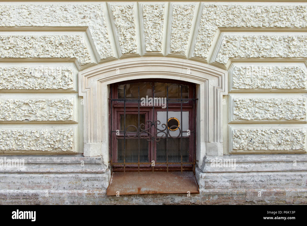 Das Fenster geschlossen mit einem Gitter mit Lüftung auf der Fassade des alten Hauses Stockfoto