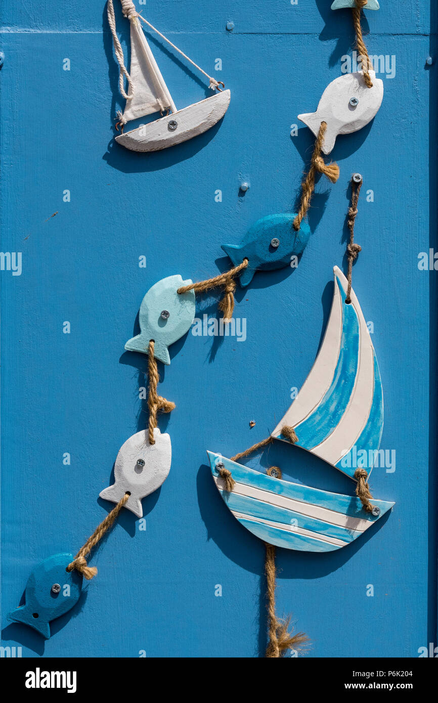 Holz- segeln Boote und Meer Fische auf einen String als Dekoration auf einem bunten Hütte Tür. Stockfoto