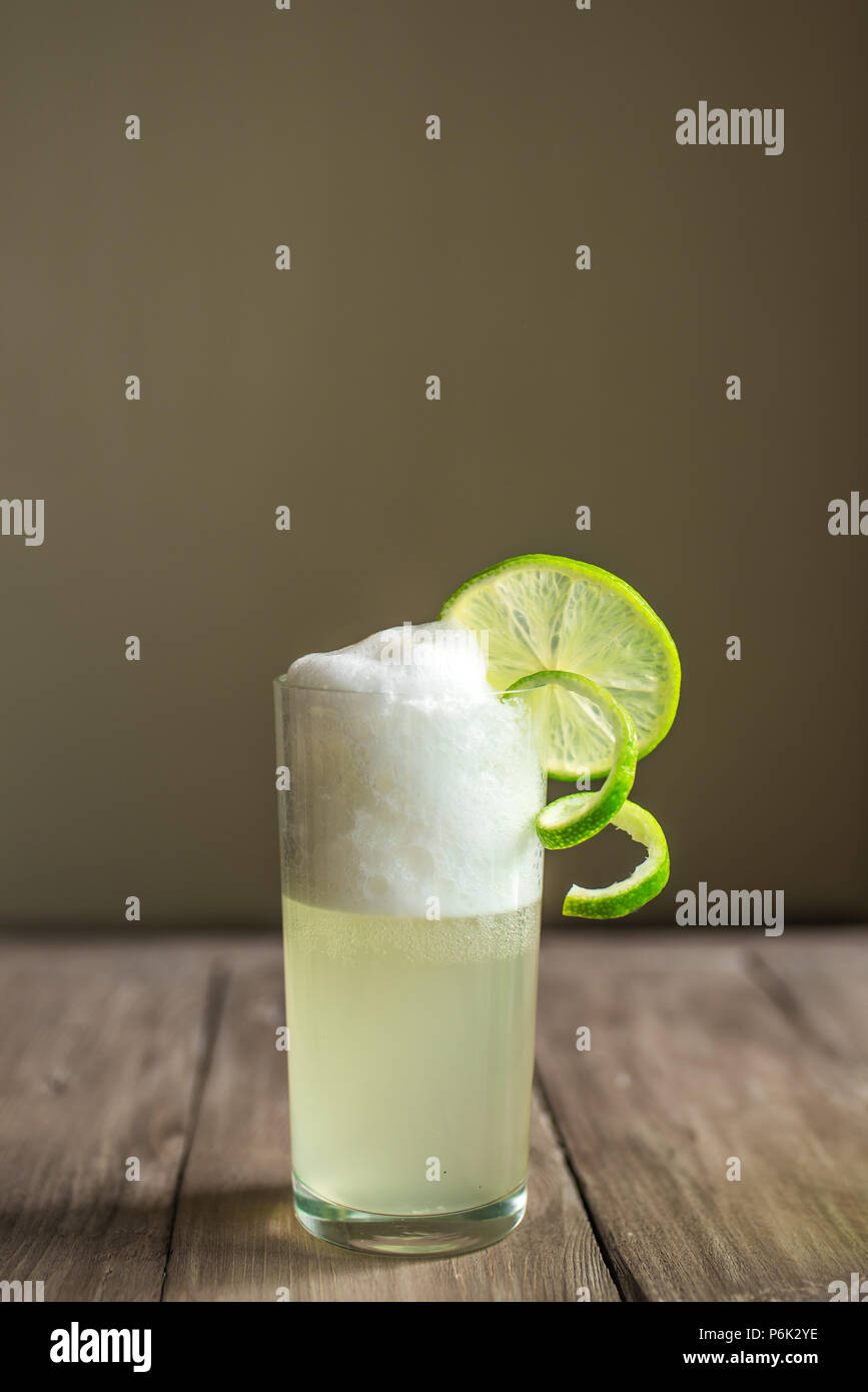 Ei Gin Fizz Cocktail mit Limetten Garnieren auf Holztisch, kopieren. Stockfoto