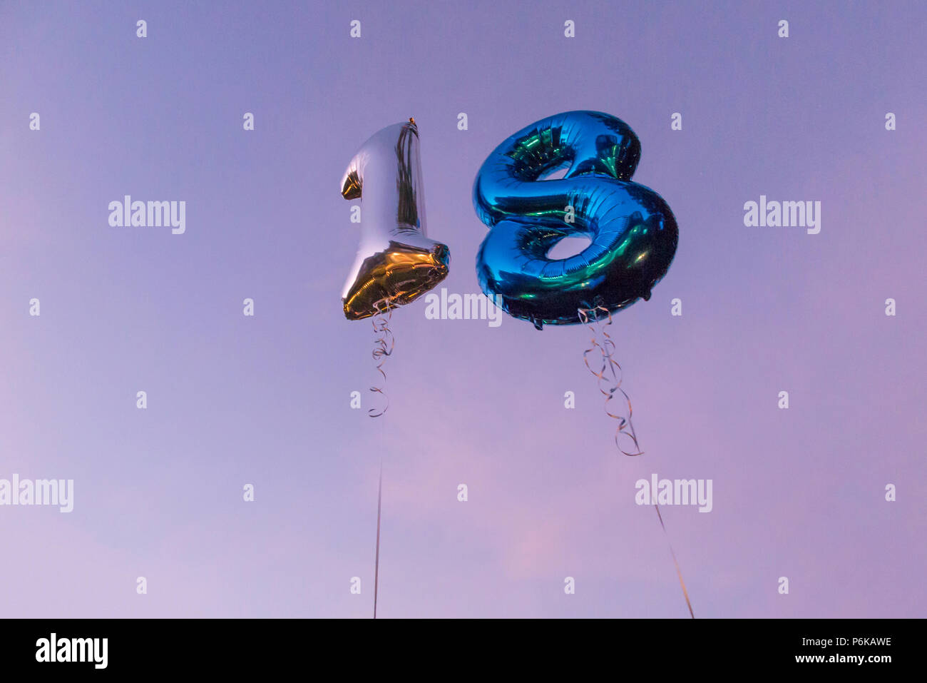 Zwei helium Luftballons feiern 18. Geburtstag vor blauem Himmel in der Dämmerung Stockfoto