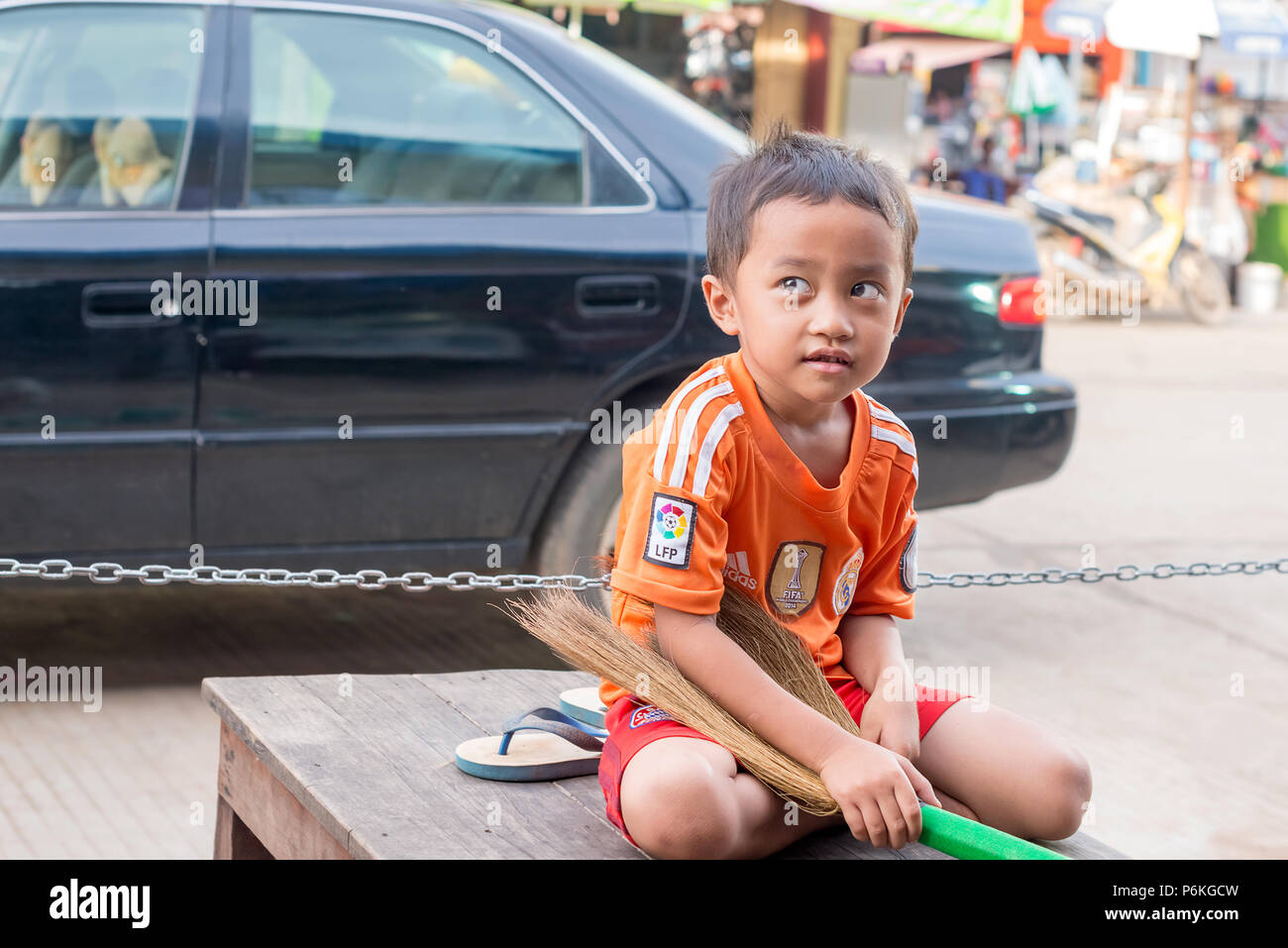 Strung Treng - November 10, 2017: junge Bboy sittin auf der Bank auf der Straße in gestochen Teng in Kambodscha. Portrait einer jungen netten Jungen. Stockfoto