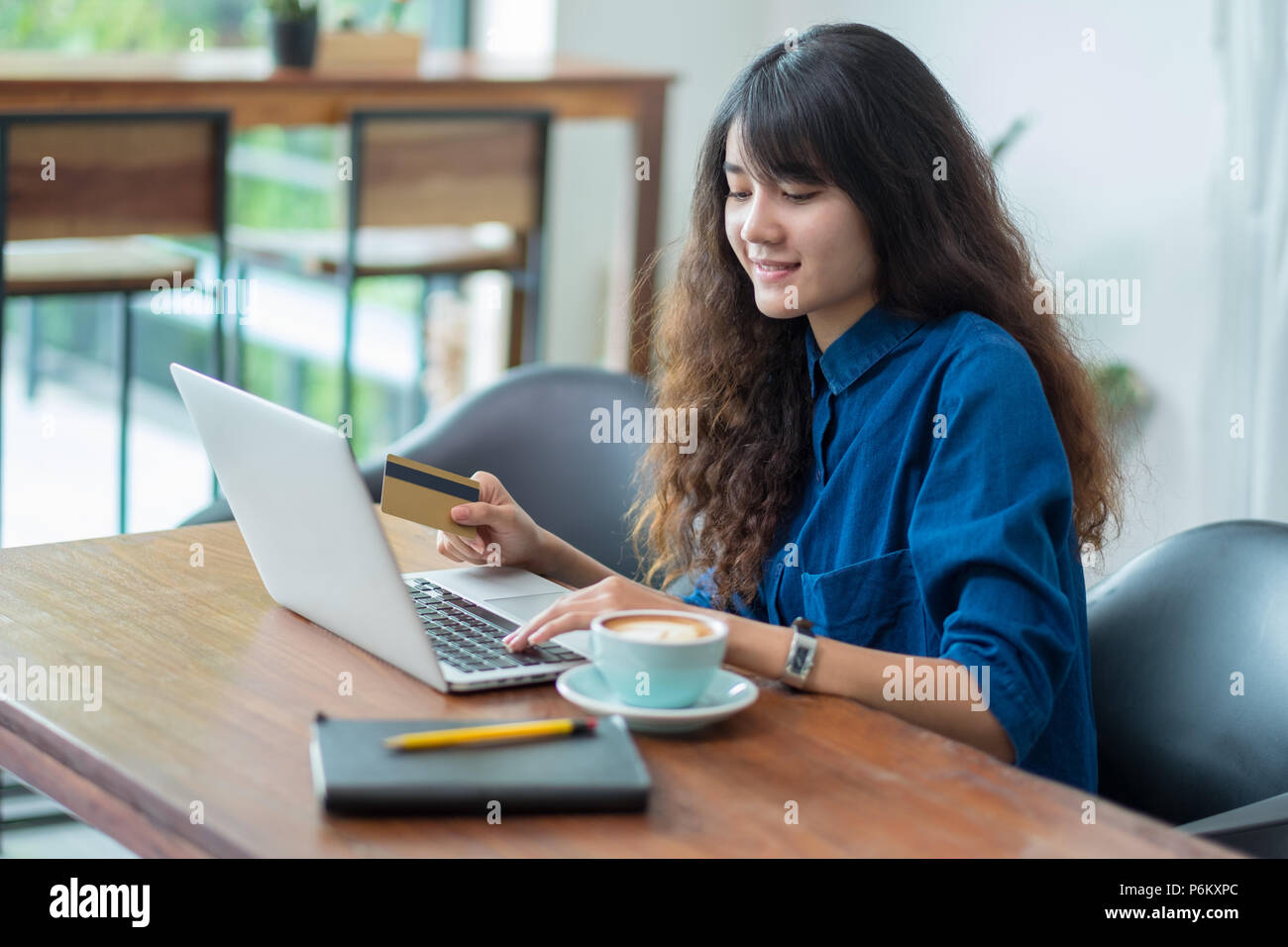 Asiatische Frau Online-Shopping mit Kreditkarte mit Laptop auf Holz Tisch im Cafe Restaurant, Digital Lifestyle concept.internet banking Zahlung Stockfoto