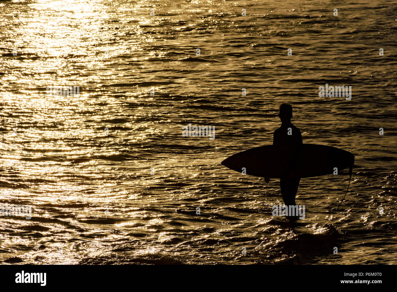 Silhouette von Surfer am Strand, am Meer in Ipanema, Rio de Janeiro bei Sonnenuntergang Stockfoto