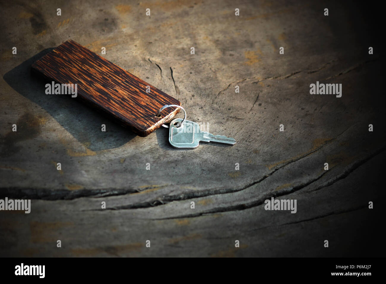 Metall Tür Schlüssel mit Schlüsselanhänger aus Holz auf Holz- Tabelle Stockfoto