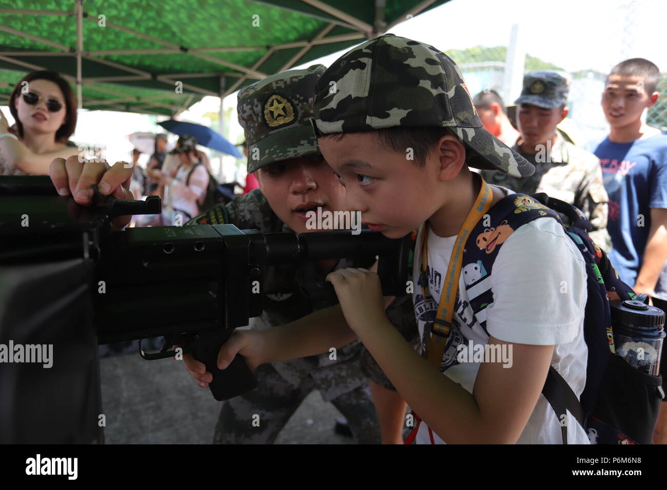 Hongkong, China. 1. Juli 2018. Ein Junge versucht Ziel mit schweren Maschinengewehr unterstützt von PLA Soldat auf der PLA HK Garnisonen open-Tag als jährliche Feier der Übergabe Hong Kongs zu nehmen. 1 - Juli 2018 Hong Kong. ZUMA/Liau Chung Ren Credit: Liau Chung Ren/ZUMA Draht/Alamy leben Nachrichten Stockfoto