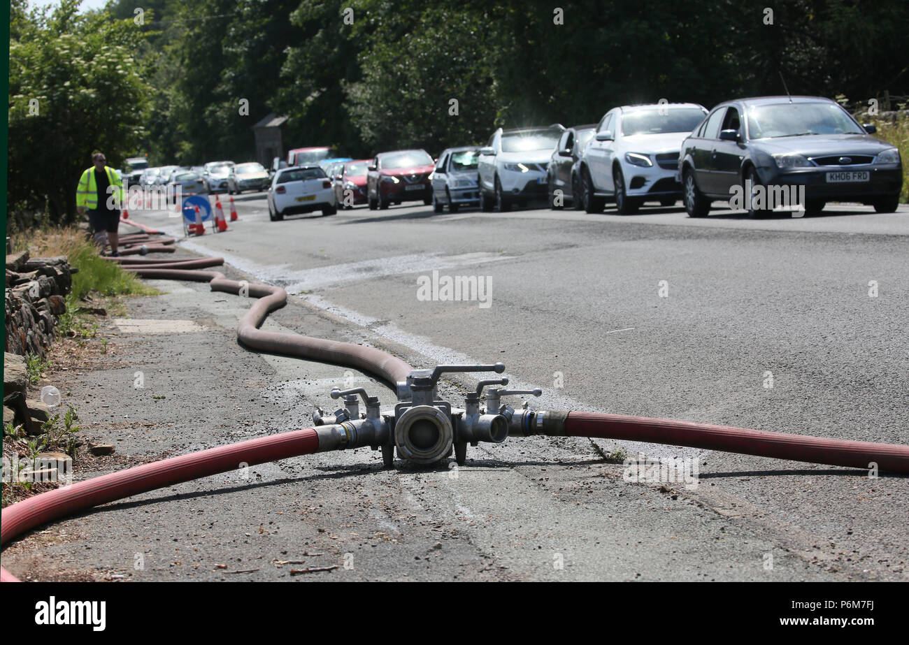 Winter Hill, Bolton, Großbritannien. 1 Jul, 2018. Löschschläuche erstrecken sich entlang einer Straße Wasser zur Verfügung zu stellen, um die Feuerwehrleute, die weiterhin mit einer Blesse Moorlandschaften über Bolton zu kämpfen, 1.Juli, 2018 (C) Barbara Cook/Alamy leben Nachrichten Stockfoto