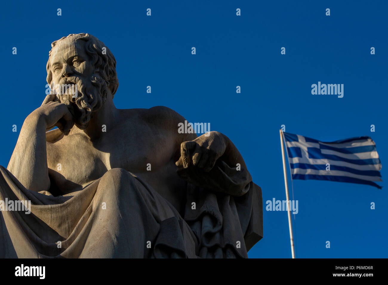 Athen, Griechenland. 29 Juni, 2018. Die marmorstatuen der antiken griechischen Philosophen Sokrates, vor der Athener Akademie steht als eine griechische Flagge am 29. Juni 2018. Credit: Angelos Tzortzinis/dpa/Alamy leben Nachrichten Stockfoto
