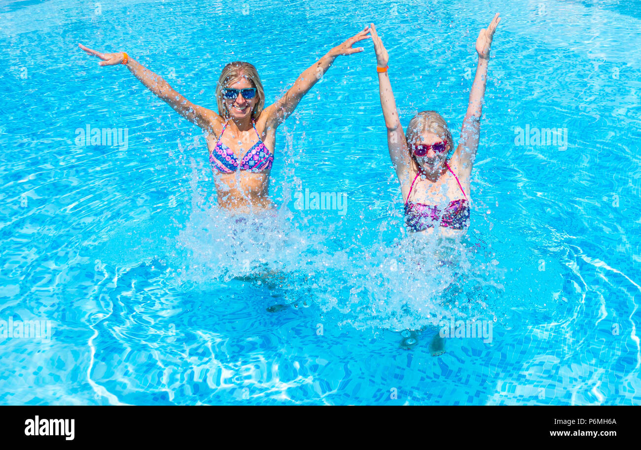 Zwei junge blonde Frau mit bunten bikini im Schwimmbad genießen. Stockfoto
