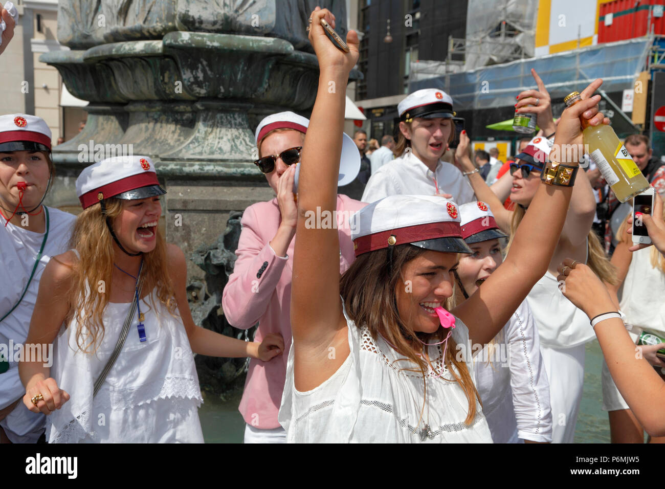 Dänische Studenten feiern ihren High School Abschluss mit der traditionellen Tanz runden und tauchen Sie ein in die Stork Brunnen auf Stroeget in Kopenhagen. Stockfoto