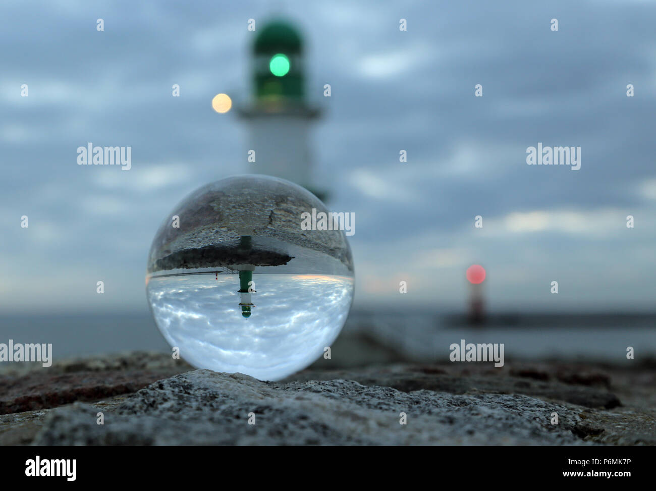 Warnemünde, Leuchttürme an der Jetty sind in der Dämmerung in einer Glaskugel wider Stockfoto