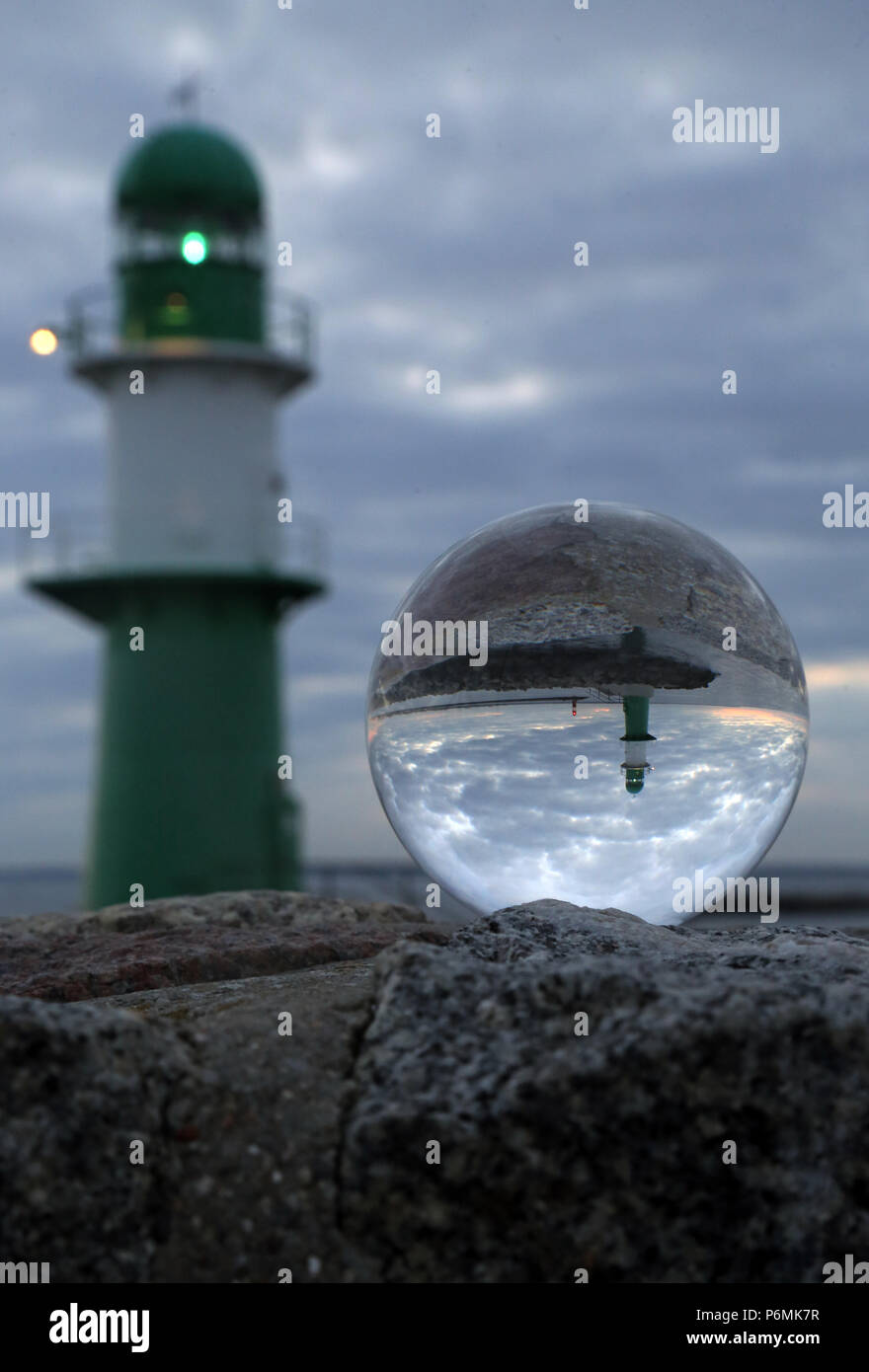 Warnemünde, Leuchttürme an der Jetty sind in der Dämmerung in einer Glaskugel wider Stockfoto