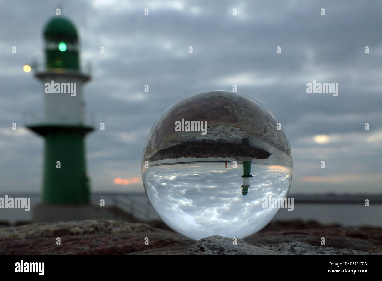 Warnemünde, Leuchttürme an der Jetty sind in der Dämmerung in einer Glaskugel wider Stockfoto