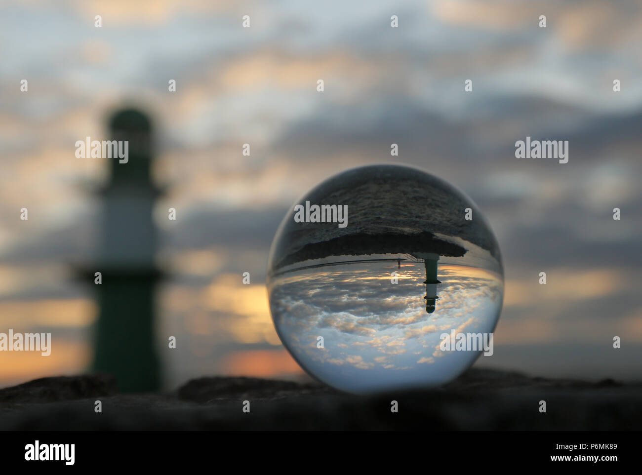 Warnemünde, Leuchttürme an der Jetty sind in der Dämmerung in einer Glaskugel wider Stockfoto