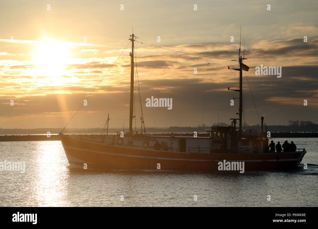 Warnemünde, Fischereifahrzeug bei Sonnenaufgang an der Ostsee Stockfoto