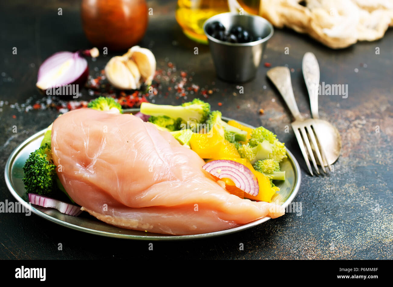 Rohes Hähnchenfilet mit frischem Gemüse auf dem Teller Stockfoto