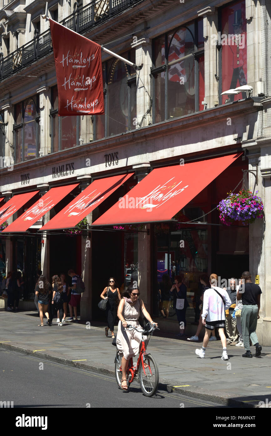 Kunden, Touristen und Mitarbeiter im Büro vorbei das Flaggschiff Hamleys Toy Store in der Regent Street in Central London im Sommer Sonnenschein. Stockfoto