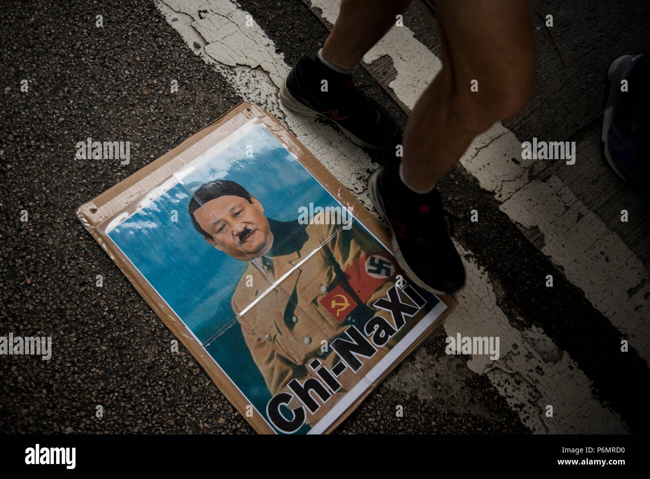 Ein Foto, das die Demonstranten zu Fuß ein Zeichen auf der Erde, die lautet: "CHI-NAXI" während der jährlichen 1. Juli Demonstration in Hongkong, China. 1. Juli 2018. Nach Angaben der Organisatoren über 50000 nehmen an der Straße von Hong Kong zu melden Sie in der jährlichen Demonstration, die in diesem Jahr 21 Jahre nach der Übergabe von der englischen Herrschaft in China. Jedes Jahr zehn Tausend auf die Straße an diesem Tag über die Themen in die Politik der Regierung zu protestieren, die von Regierungsbeamten zu Skandalen und das tägliche Leben Probleme, sie sind Ausdruck der hier von der Öffentlichen in diesem jährlichen Demonstration. Stockfoto