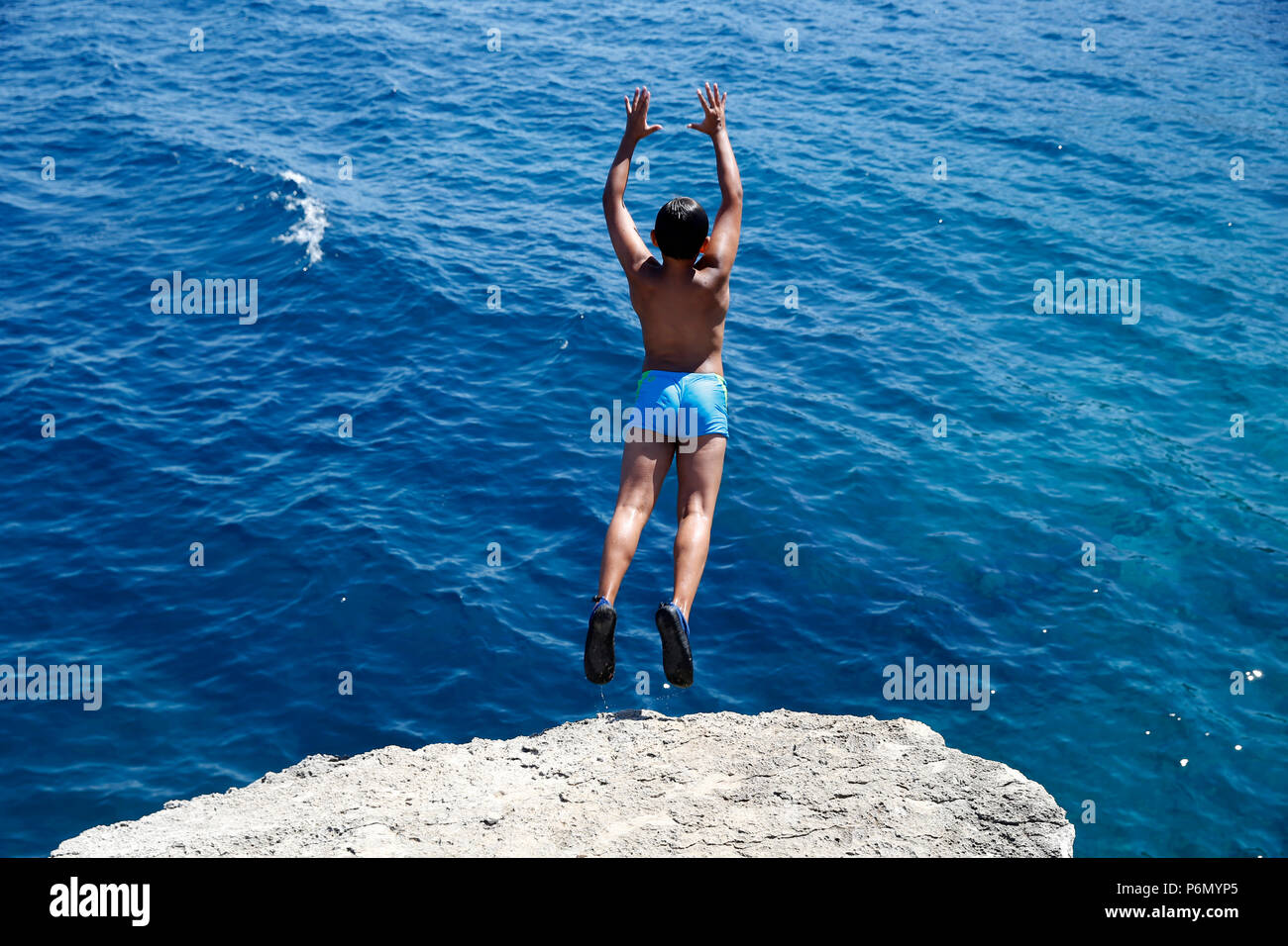 11-jähriger Junge von einem Felsen ins Meer im Salento, Italien springen. Stockfoto 11-jähriger Junge von einem Felsen ins Meer im Salento, Italien springen. Stockfoto