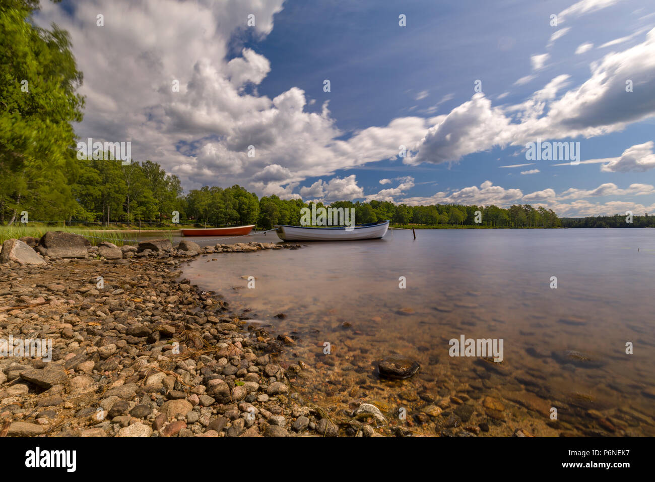 Zwei angelegten Boote von felsigen Strand an einem schönen Sommertag am ruhigen See Uspen, Schweden Stockfoto