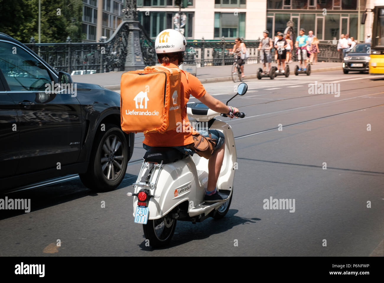 Berlin, Deutschland - Juni 2018: einen Treiber von Lieferando, ein Lebensmittel Lieferservice, bei scooter im Verkehr in Berlin, Deutschland Stockfoto