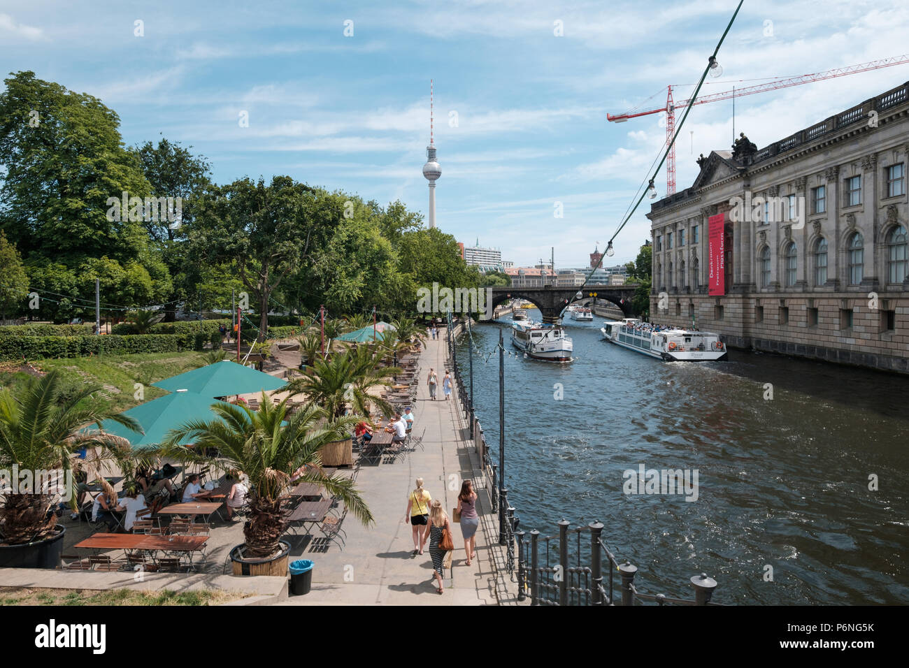 Berlin, Deutschland - Juni 2018: Leute an der Strand Bar neben Spree mit touristischen Boote und den Fernsehturm im Hintergrund Stockfoto
