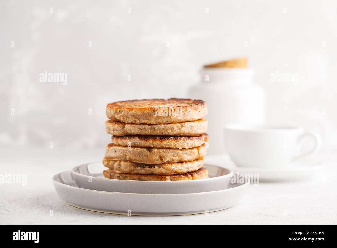 Vegane Pfannkuchen mit Chia Samen auf eine weiße Platte, weisser Hintergrund. Gesunde vegane Ernährung Konzept. Stockfoto