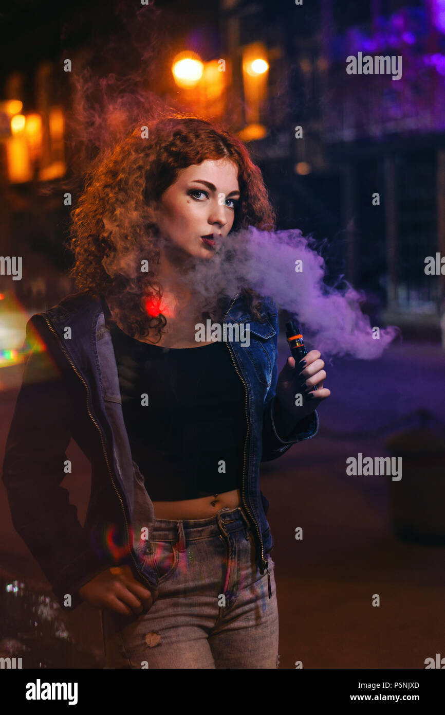 Junge attraktive rothaarige Mädchen raucht elektronische Zigarette
