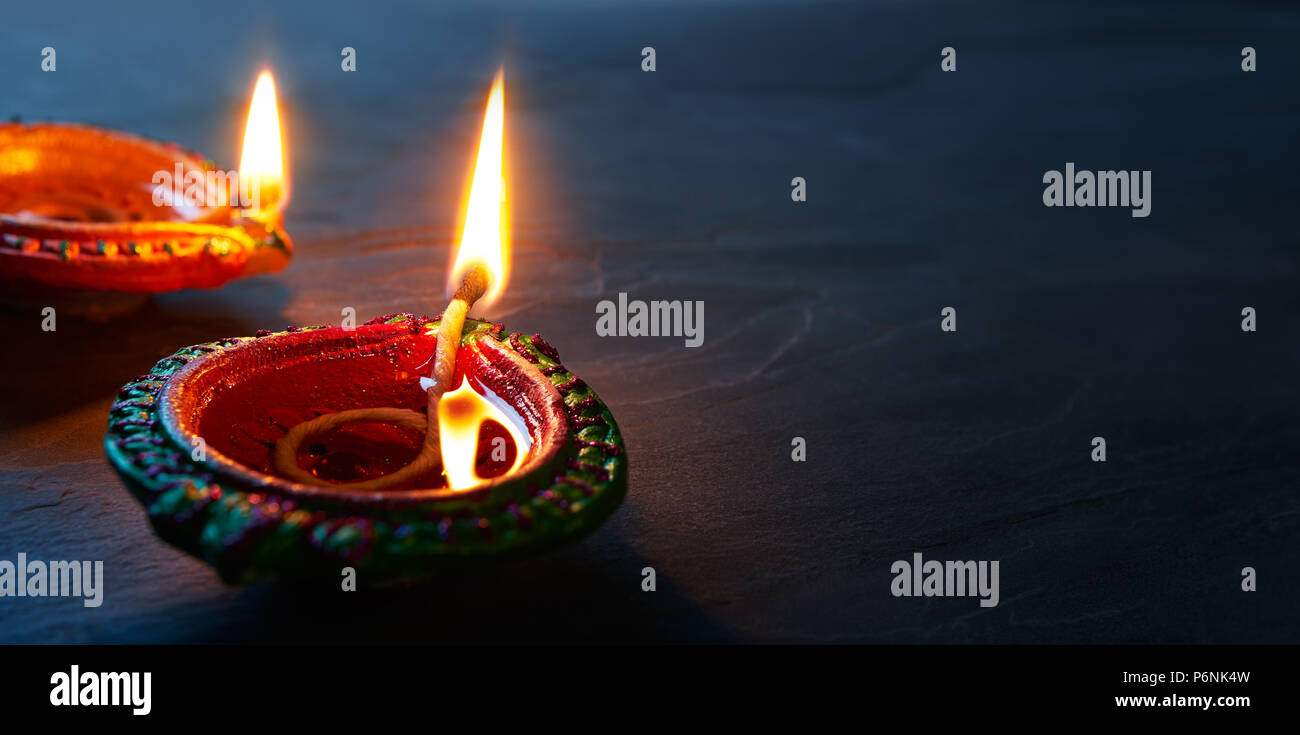 Happy Diwali - Nahaufnahme von lit Diya Lampen auf dem Boden Stockfoto