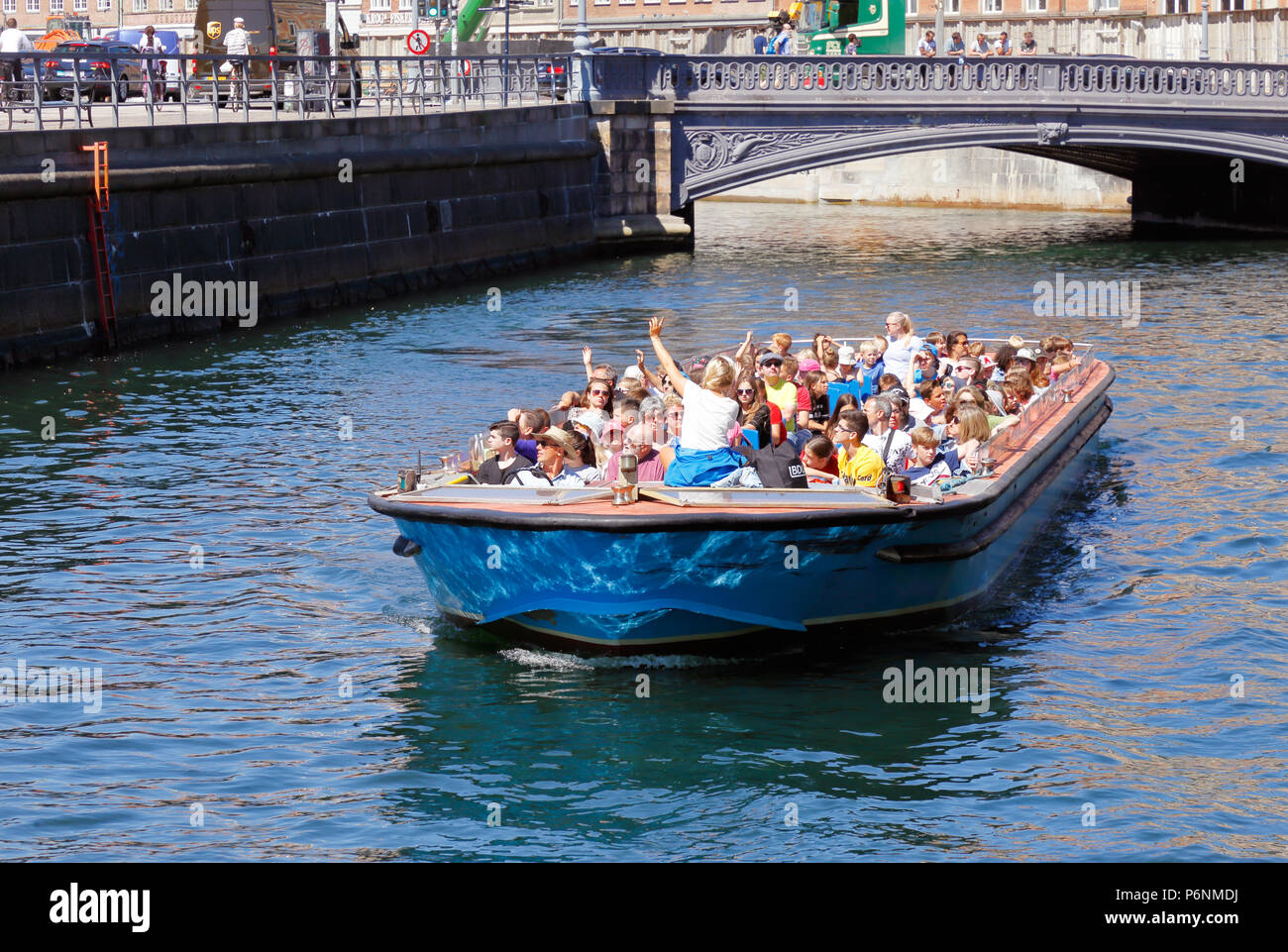 Kopenhagen, Dänemark - 27. Juni 2018: Menschen Reiten in einem oben offenen Schiff auf ein Grachtentour bei Holmens Brücke. Stockfoto