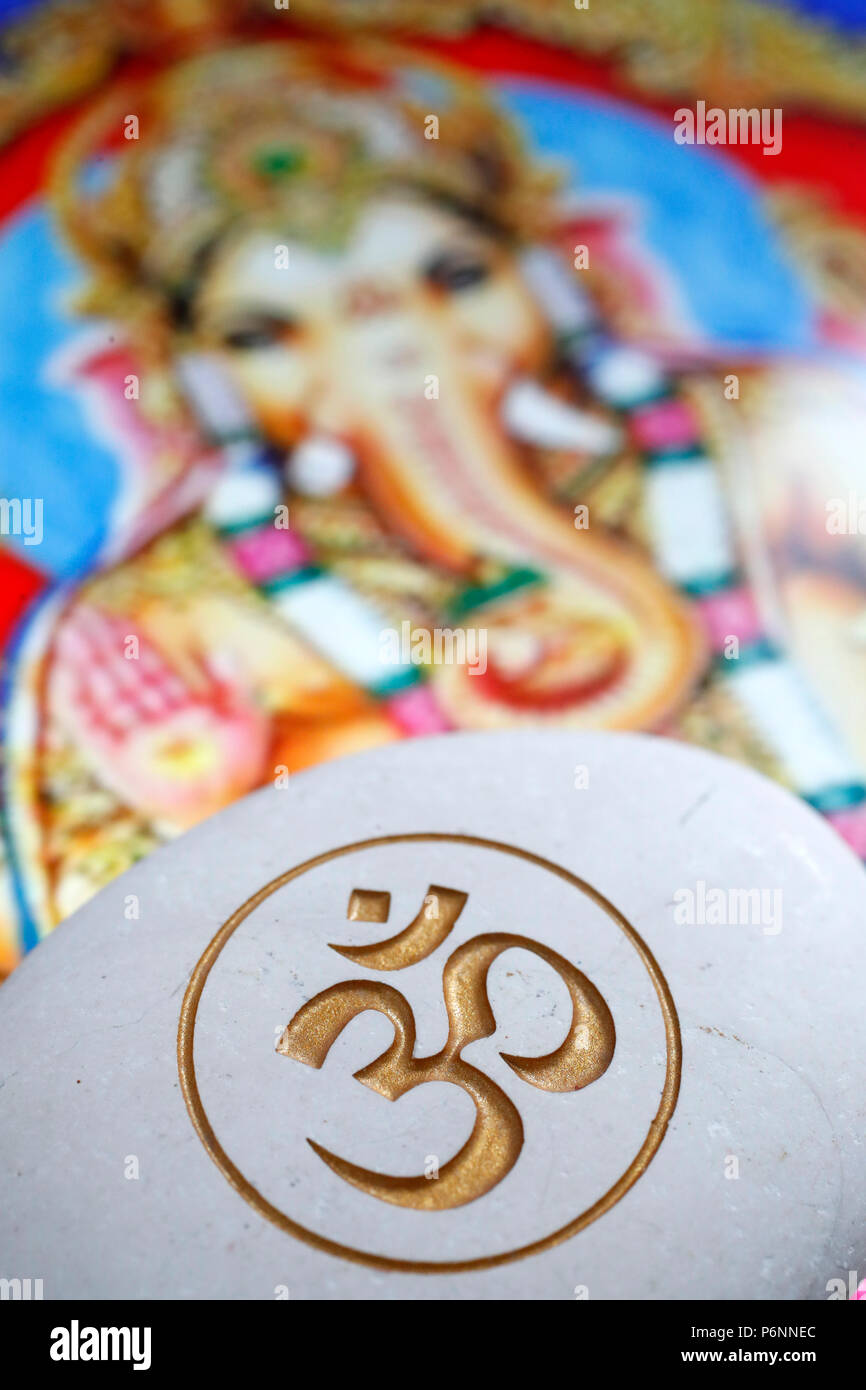 Die Om oder Aum Symbol von Hinduismus und Buddhismus auf einen weissen Stein. Bild von Ganesha auch als Ganapati auf einem Tablet bekannt. Stockfoto