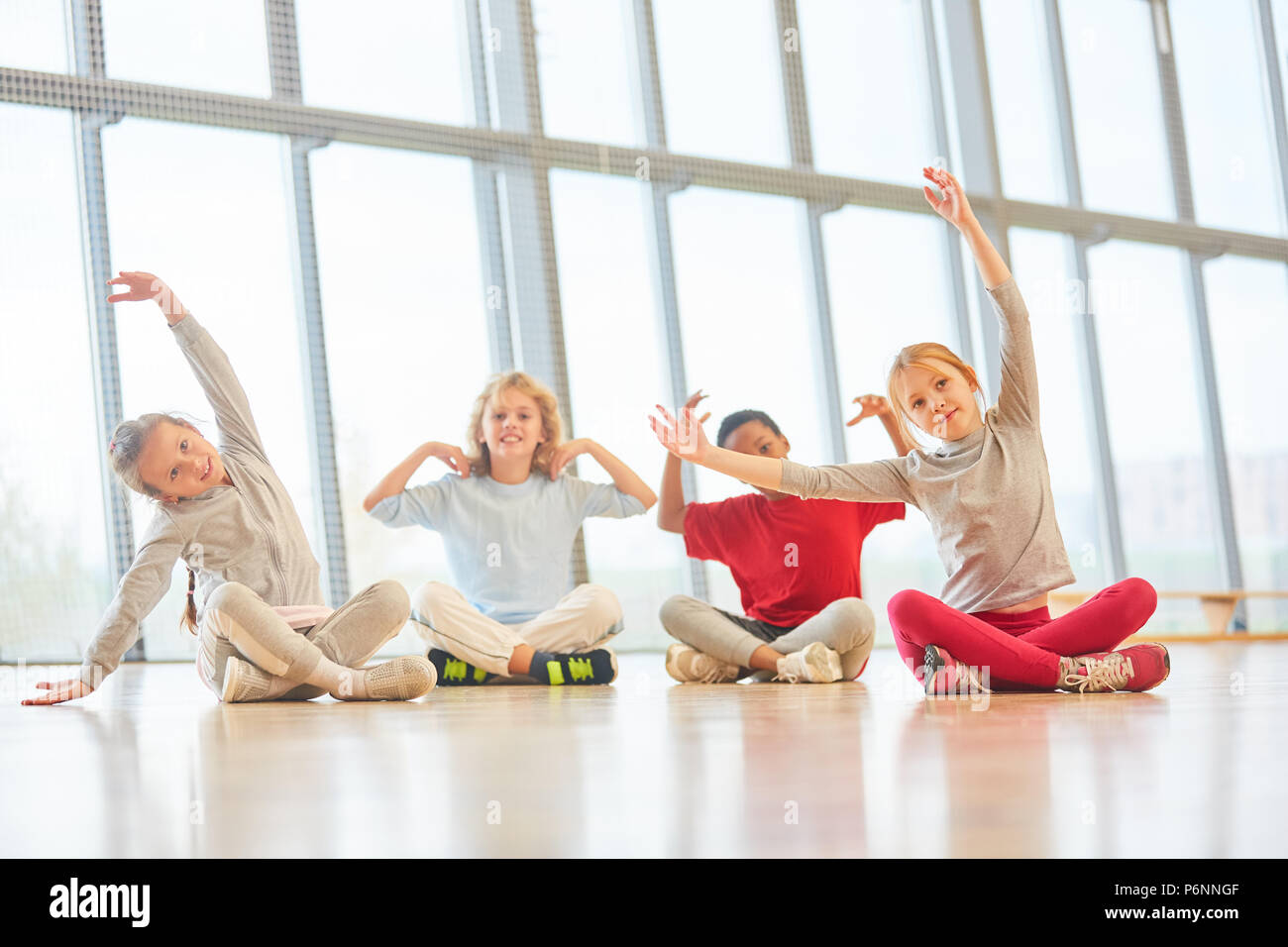 Gruppe von Kindern macht Stretching im Sportunterricht in der Grundschule Stockfoto