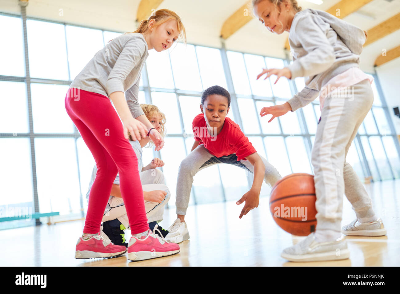 Gruppe von Kindern an einem Basketballspiel in der Grundschule Sportunterricht Stockfoto