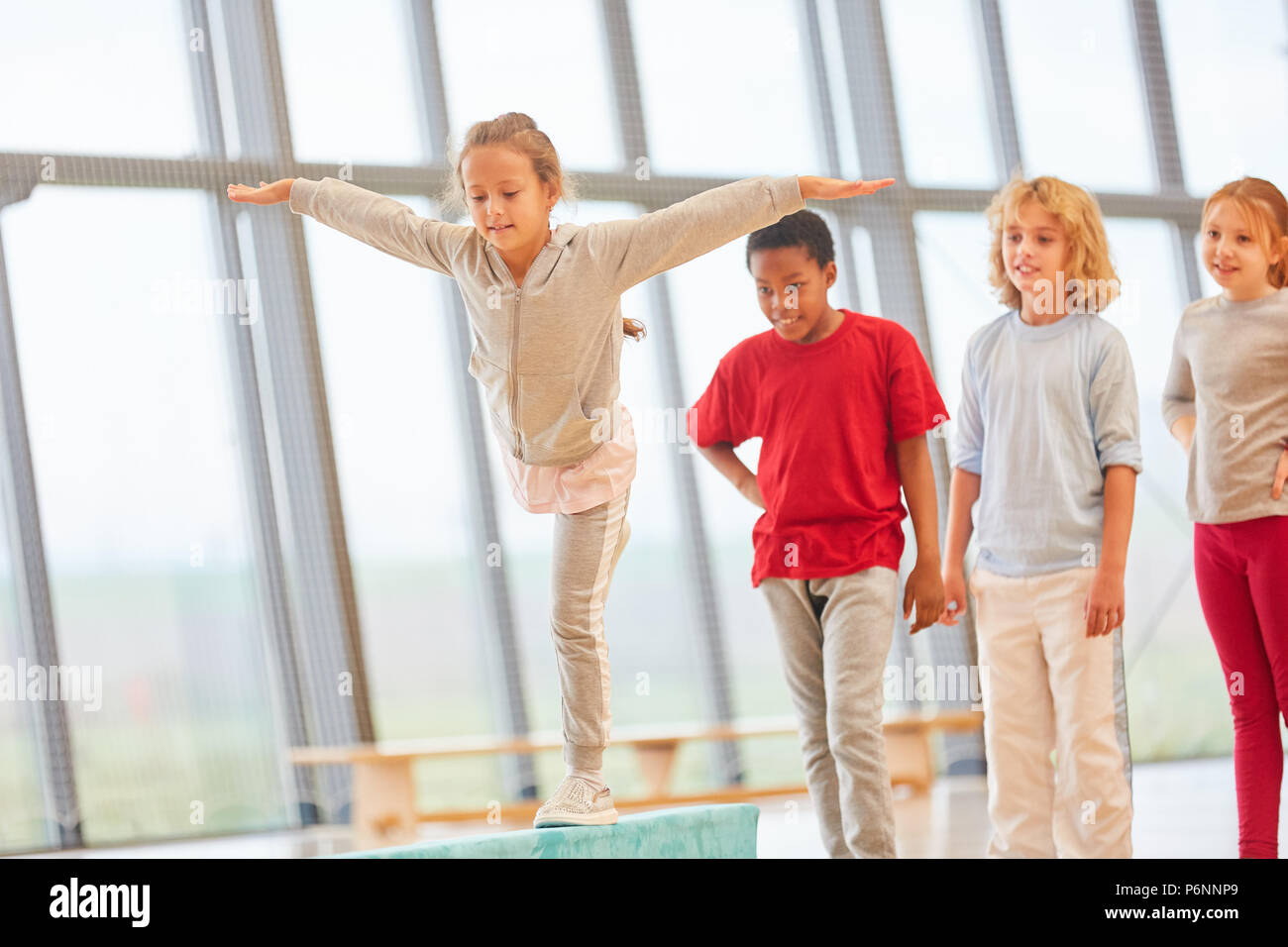 Mädchen Züge Balance auf Schwebebalken in der Grundschule Sportunterricht Stockfoto