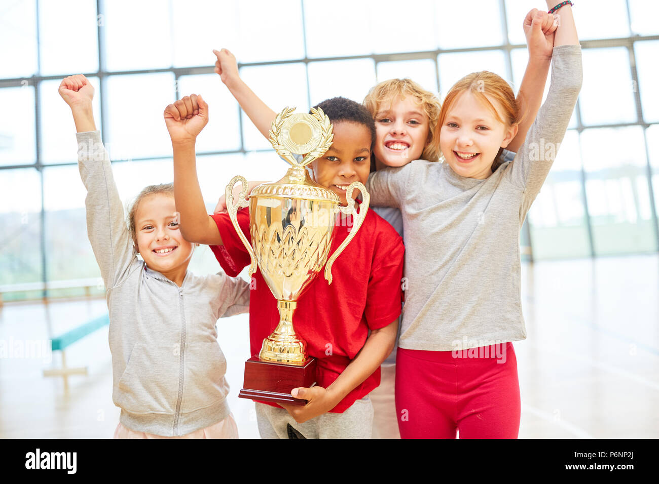 Kinder- team Prost mit einer Schale an einer Schule Sport Wettbewerb Stockfoto