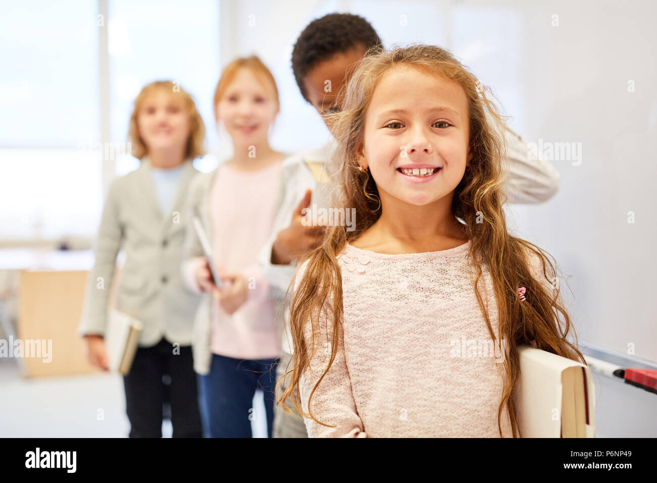 Happy girl als Schule für Anfänger in der Gruppe der Schüler der Grundstufe Stockfoto