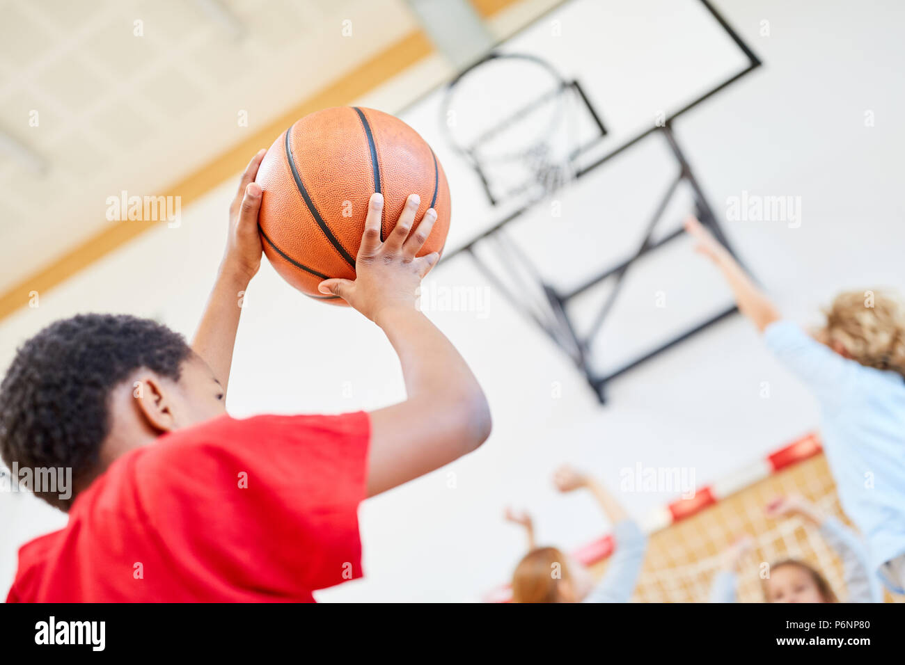 Junge spielt Basketball in Training oder Wettkampf im Sportunterricht Stockfoto