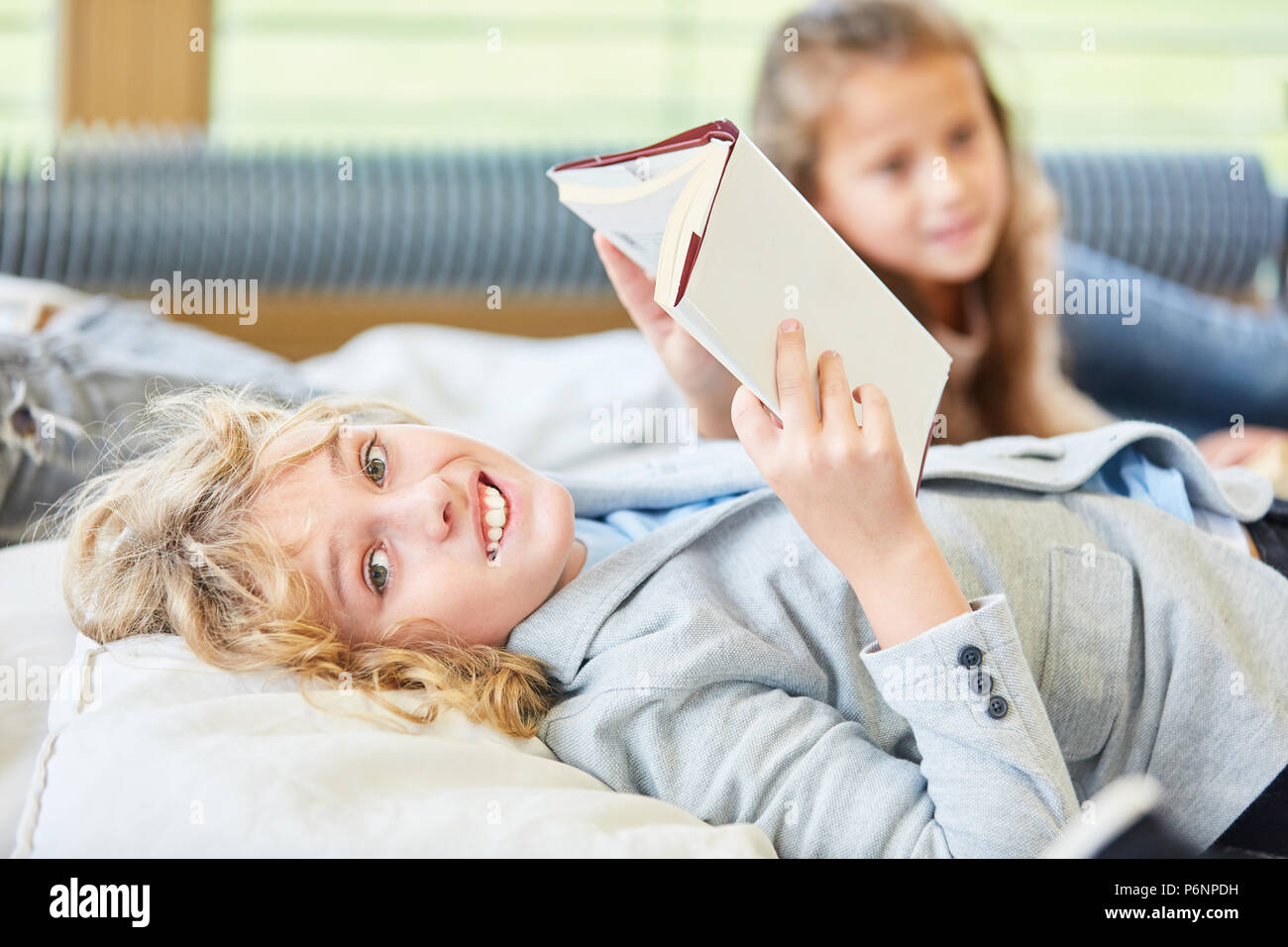 Happy Boy ist das Lesen ein Kinderbuch oder Sachbuch entspannt in den Urlaub Stockfoto