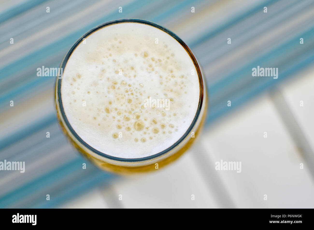 Blick von oben auf einen schaumigen Tasse kaltes Bier an einem heissen Sommertag in einem Restaurant am Meer Stockfoto