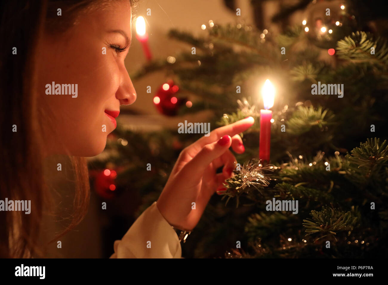 Mädchen betrachten eine Kerze auf einem Weihnachtsbaum. Genf. Die Schweiz. Stockfoto