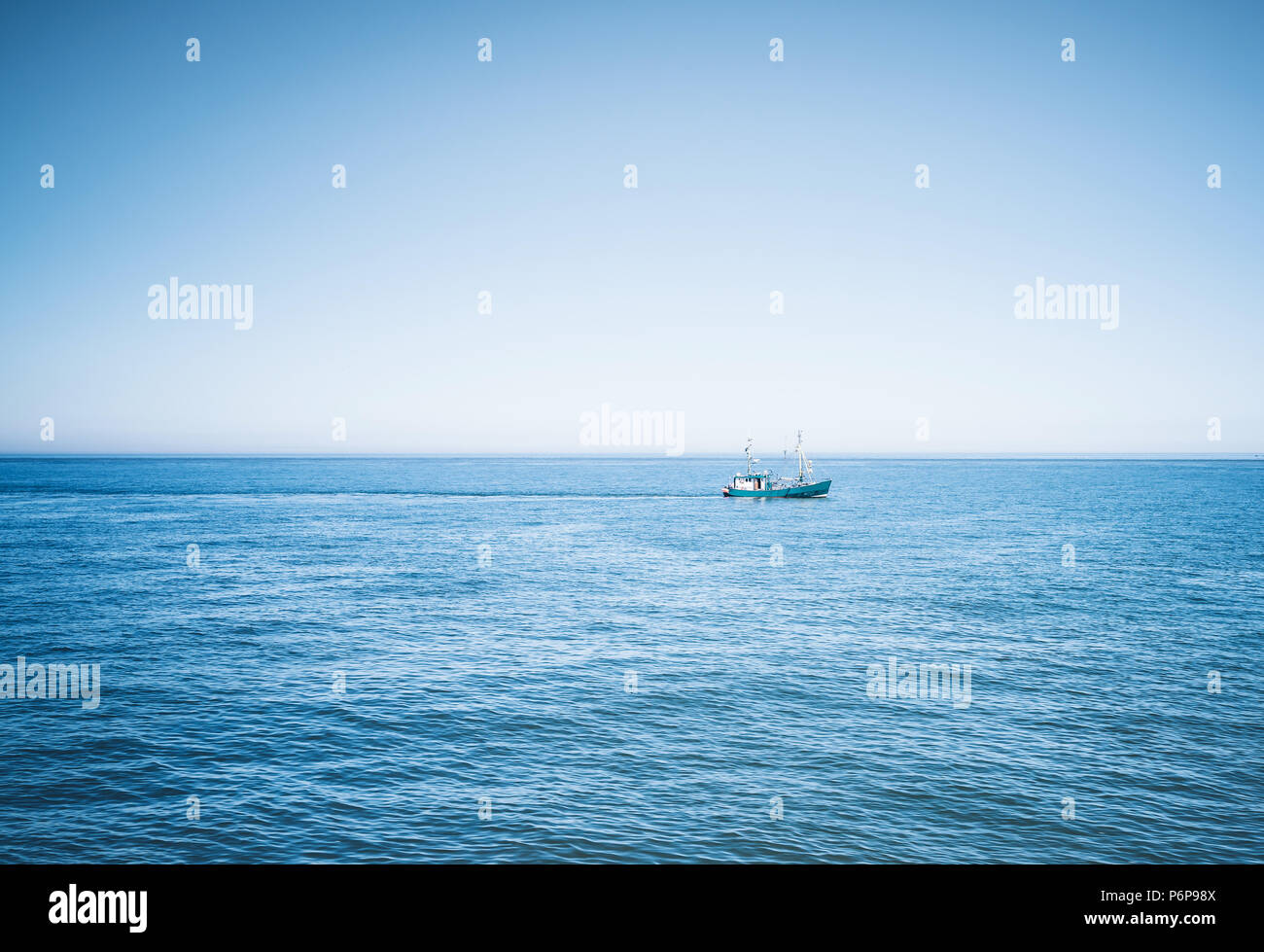 Fischereifahrzeugs auf blauen Ozean gegen den klaren Himmel Stockfoto
