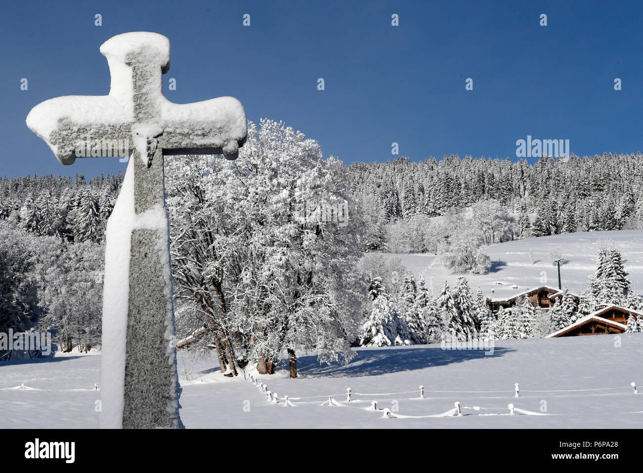 Kreuz aus Stein mit Schnee im Winter. Megeve. Frankreich. Stockfoto